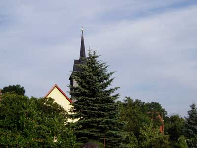 Hinter den Gärten die Kirche.